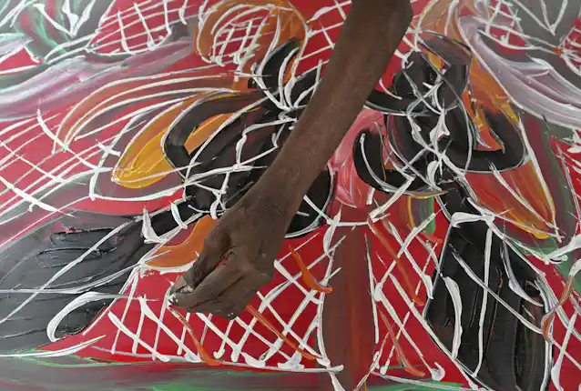 Yolngu artist Dhambit Mununggurr works on a painting during the 2023 Garma Festival. Mick Tsikas/AAP